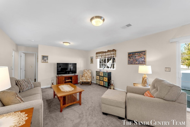 living room featuring carpet, visible vents, and baseboards