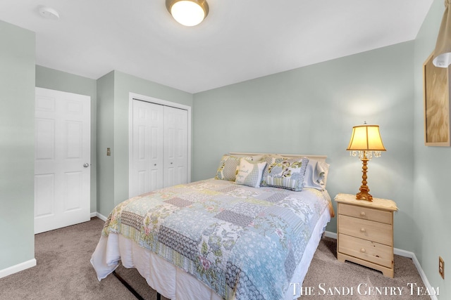 carpeted bedroom featuring a closet and baseboards