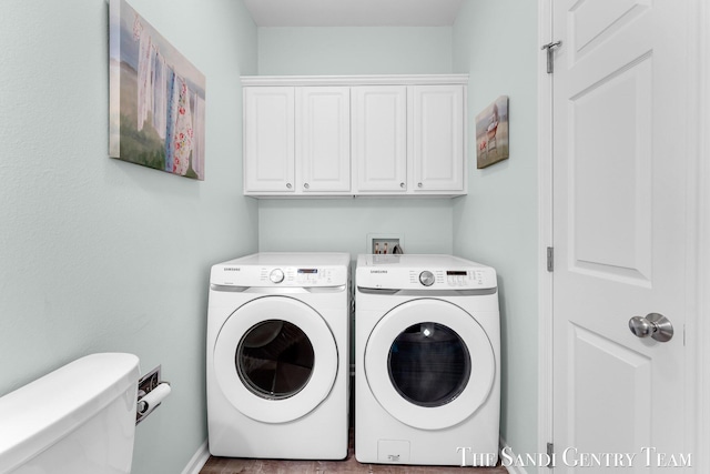 clothes washing area featuring washing machine and dryer and cabinet space