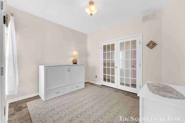 interior space featuring french doors, wood finished floors, visible vents, and baseboards