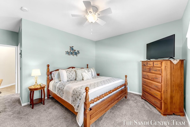 bedroom featuring a ceiling fan, light colored carpet, and baseboards