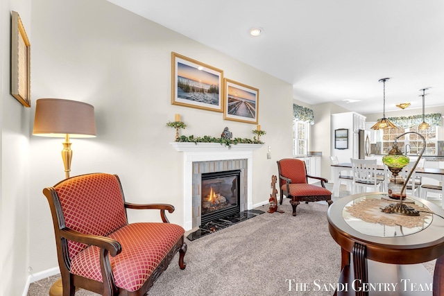 interior space with carpet floors, a tile fireplace, and baseboards