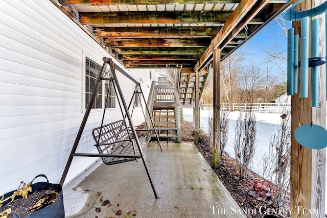 view of patio featuring fence and stairs