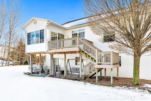 snow covered property with stairway