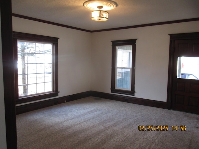 unfurnished room featuring carpet floors, ornamental molding, and baseboards