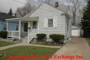 bungalow with an outbuilding, a porch, a garage, driveway, and a chimney