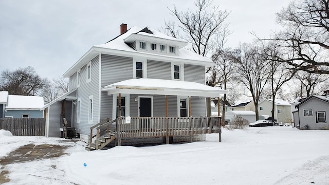 traditional style home featuring covered porch, a chimney, and fence