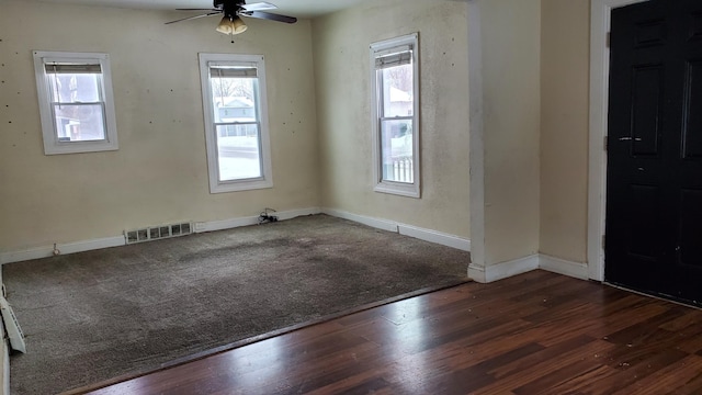 spare room featuring ceiling fan, wood finished floors, visible vents, and baseboards