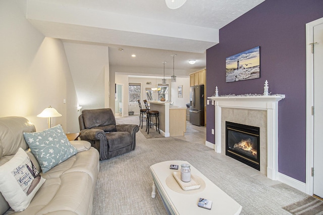 living room featuring light carpet, a fireplace, and baseboards