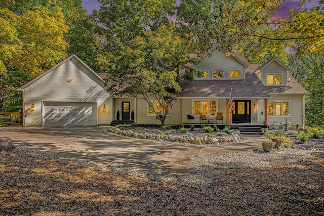 view of front of property featuring an attached garage, covered porch, and concrete driveway