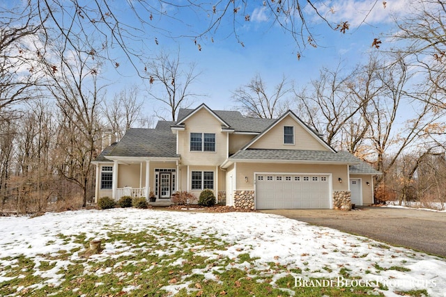 traditional-style home featuring a garage, stone siding, aphalt driveway, and roof with shingles