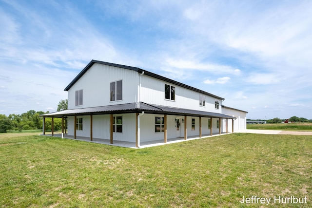 rear view of property featuring metal roof and a yard