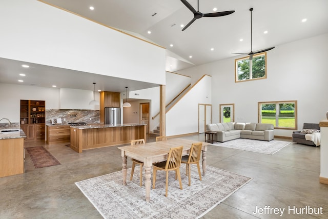 dining room featuring a ceiling fan, stairway, concrete flooring, high vaulted ceiling, and recessed lighting