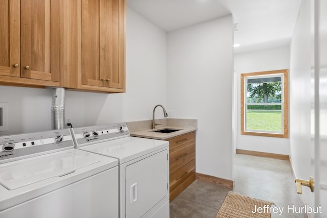 laundry room featuring washer and dryer, cabinet space, a sink, and baseboards