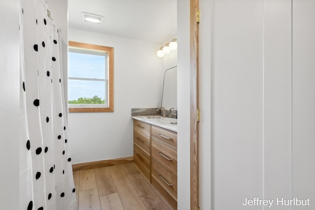 bathroom with visible vents, wood finished floors, vanity, and baseboards