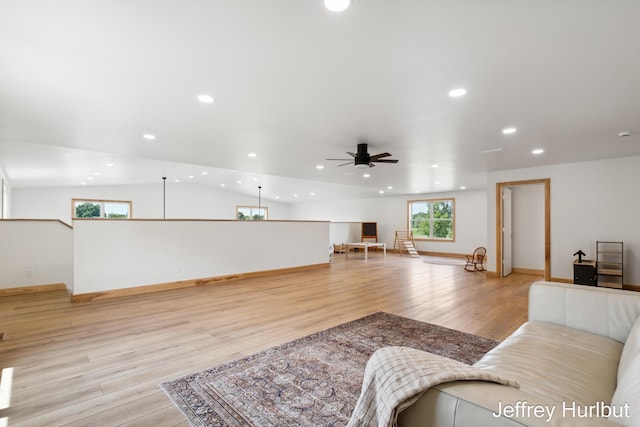 living room with baseboards, a ceiling fan, lofted ceiling, light wood-type flooring, and recessed lighting