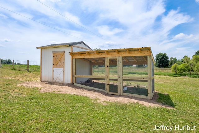 view of poultry coop with a lawn and fence