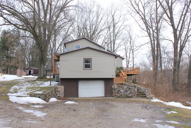 view of snowy exterior featuring stairs and an attached garage