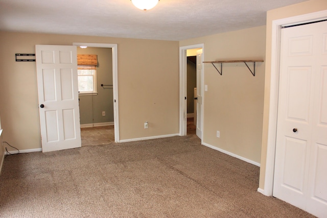 unfurnished bedroom with carpet floors, a closet, and baseboards