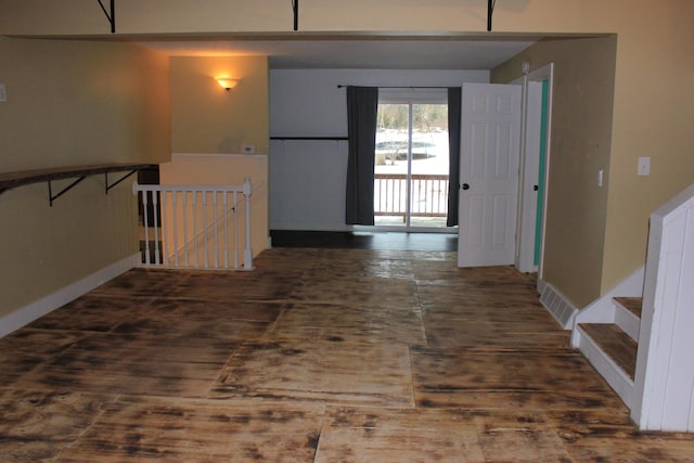 hallway with baseboards, visible vents, and an upstairs landing