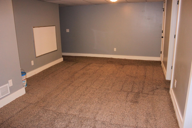 finished basement featuring carpet floors, baseboards, visible vents, and a drop ceiling