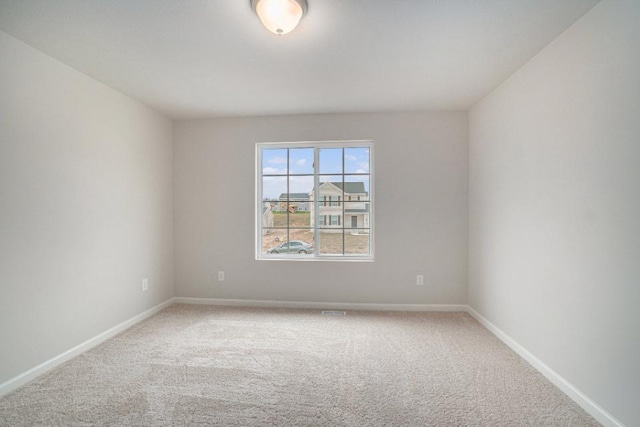 carpeted spare room featuring baseboards