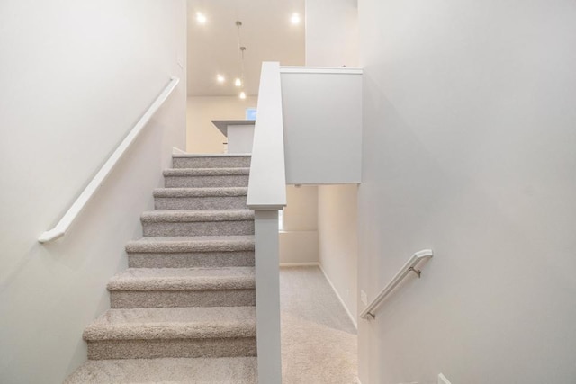 staircase featuring carpet flooring