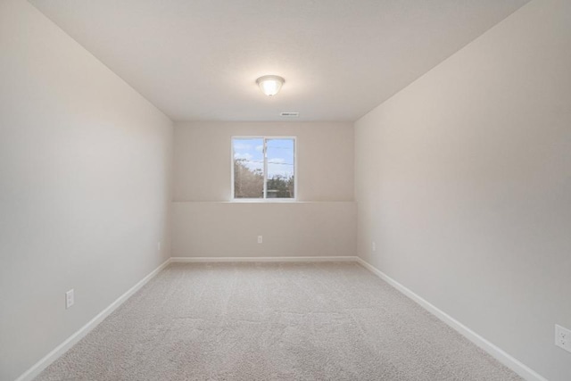 unfurnished room featuring carpet floors, visible vents, and baseboards