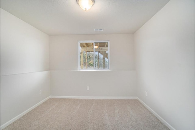 carpeted empty room featuring visible vents and baseboards