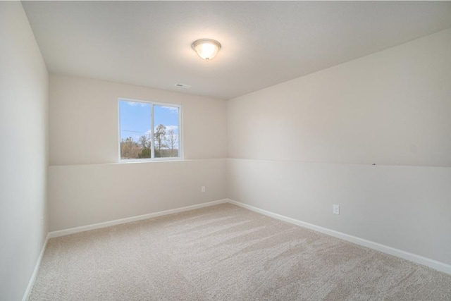 carpeted spare room featuring visible vents and baseboards