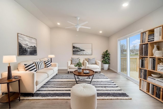 living area with lofted ceiling, recessed lighting, a ceiling fan, baseboards, and light wood-style floors