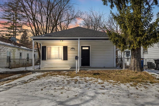 view of front of home featuring roof with shingles and fence