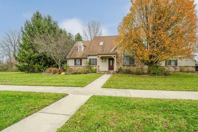 view of front of house featuring a shingled roof, a front yard, and stone siding