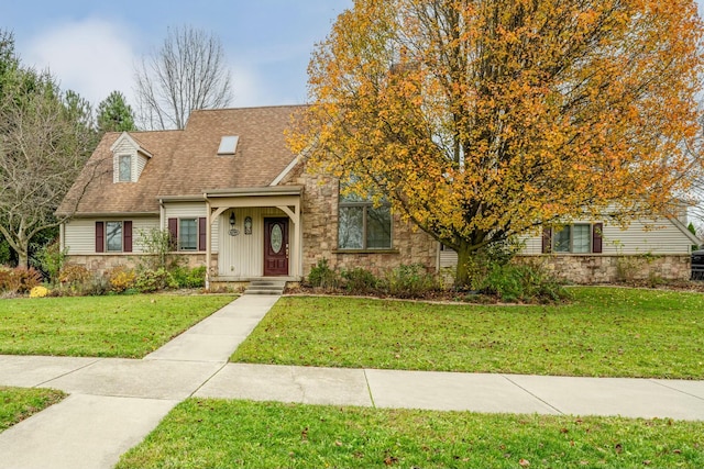 view of front of home featuring stone siding, roof with shingles, and a front yard