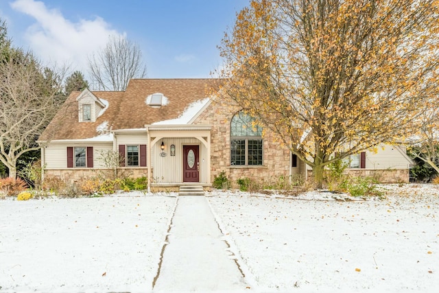 view of front of property featuring stone siding and roof with shingles