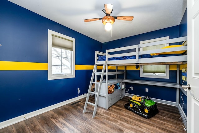 bedroom featuring wood finished floors, visible vents, and baseboards