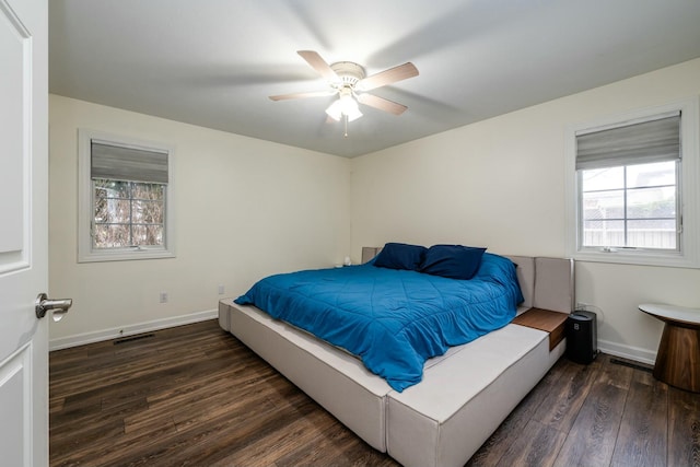 bedroom featuring baseboards, visible vents, dark wood finished floors, and a ceiling fan