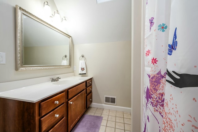 full bath featuring baseboards, visible vents, tile patterned floors, vaulted ceiling, and vanity