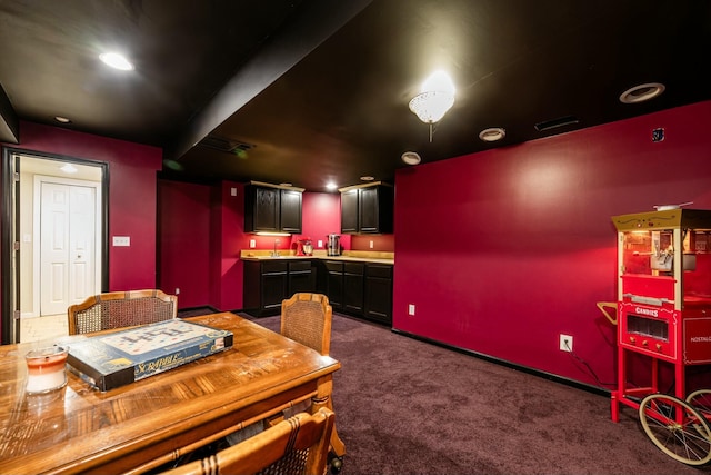 dining area featuring dark carpet and baseboards