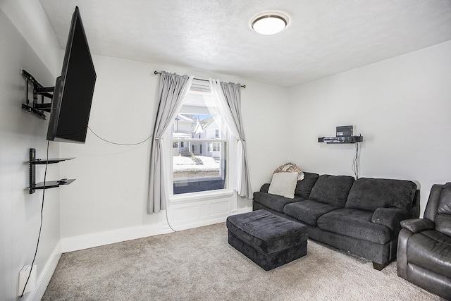 carpeted living area with baseboards and a textured ceiling