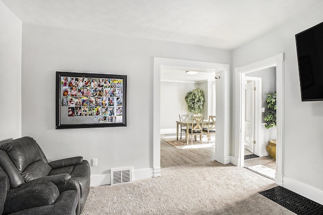 carpeted living room featuring visible vents and baseboards