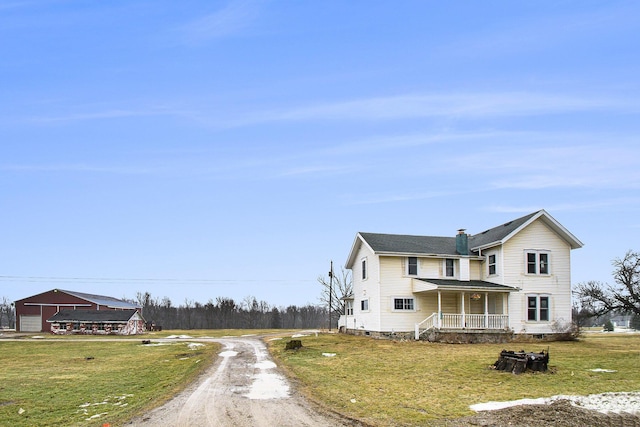 view of front of home featuring dirt driveway, a porch, and a front yard