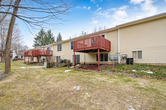 rear view of house featuring a lawn and a deck