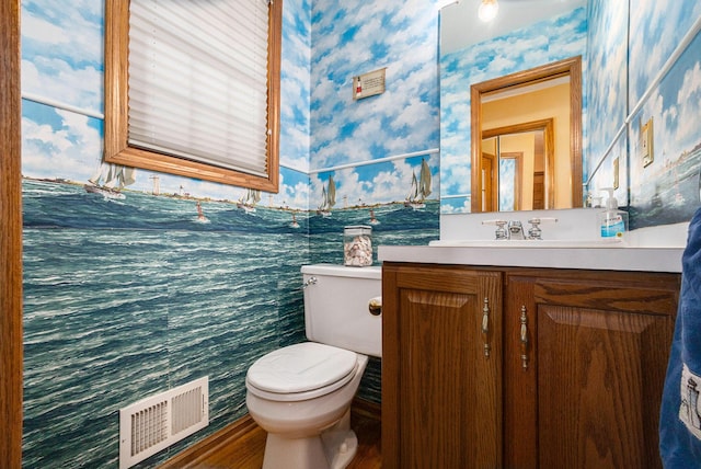 bathroom featuring toilet, vanity, visible vents, and wallpapered walls