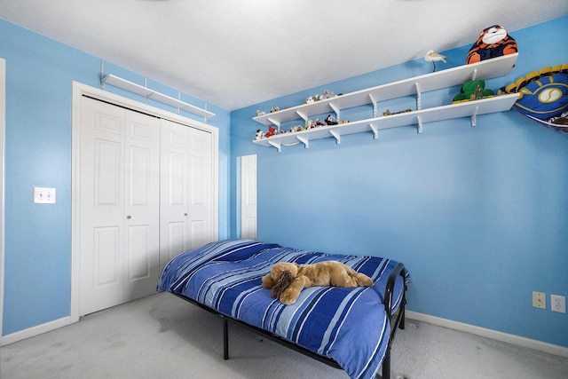 carpeted bedroom featuring baseboards and a closet