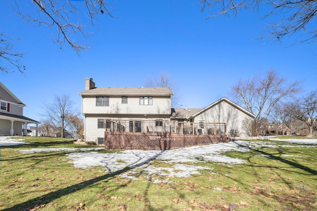 back of house featuring a deck, a yard, and a chimney