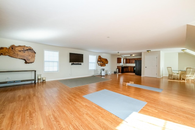 exercise room with wood finished floors and baseboards