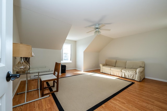 interior space with ceiling fan, baseboards, vaulted ceiling, and wood finished floors