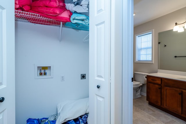 laundry area with light tile patterned floors, hookup for an electric dryer, laundry area, washer hookup, and a sink