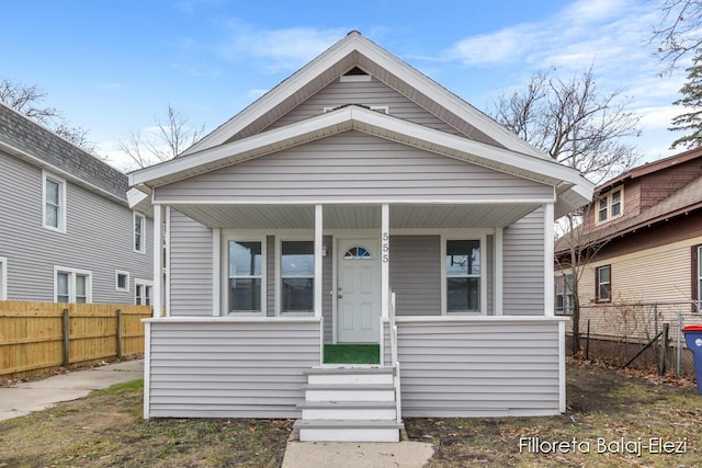 view of front of home featuring a porch and fence